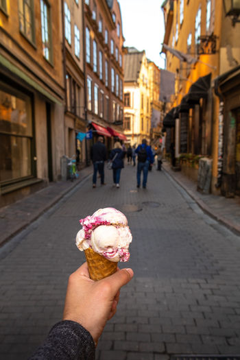 Woman holding ice cream cone on street