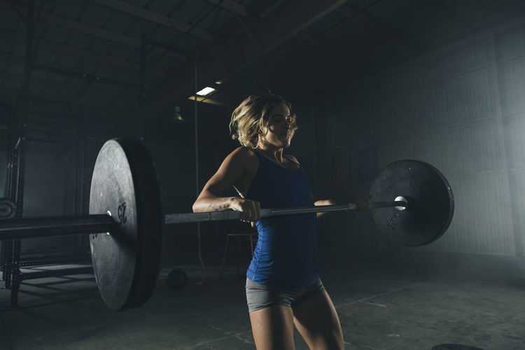 Female athlete lifting barbell in gym