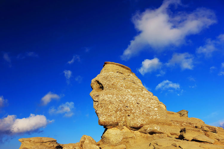 Sphinx of rock formations against blue sky