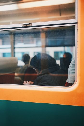 Woman sitting in train seen through train window
