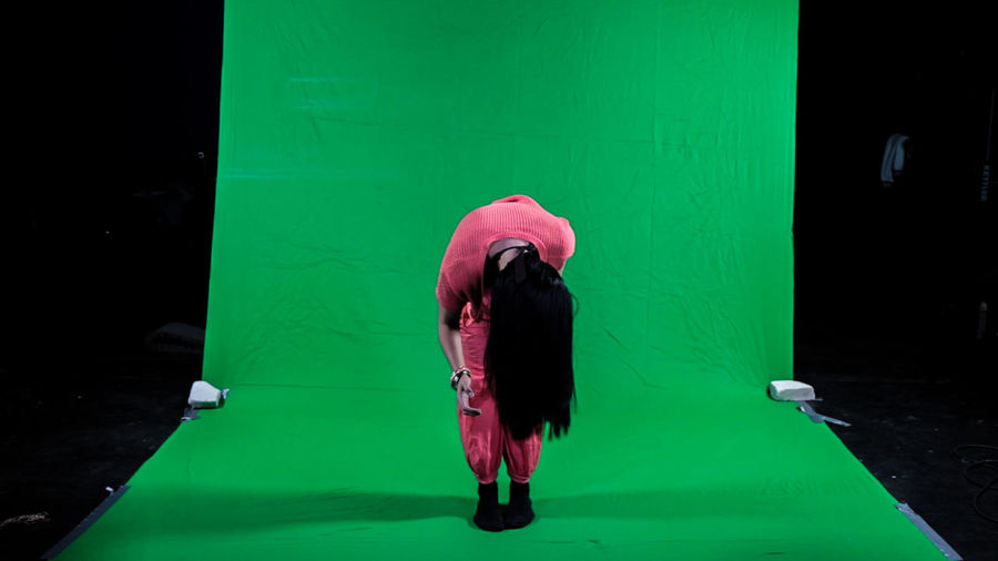 Full length of woman bending in studio