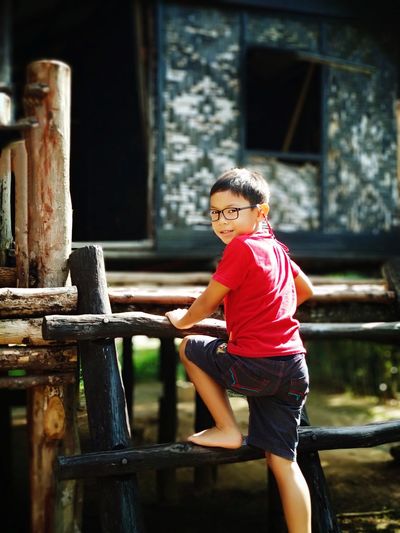 Portrait of smiling boy climbing fence