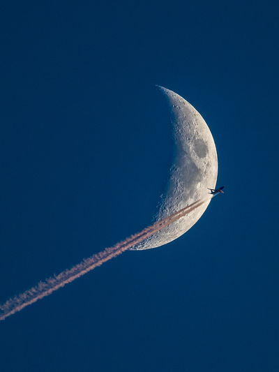 Low angle view of airplane against moon