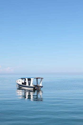 An empty motor boat in sulawesi sea against clear sky