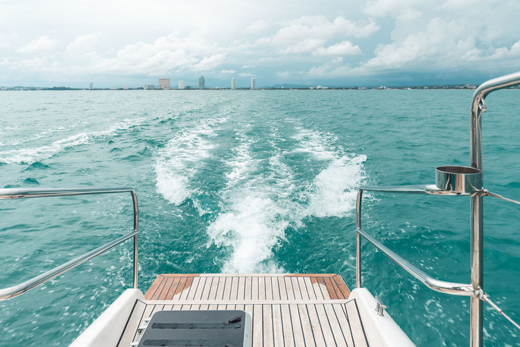 Sea wave from catamaran yacht engine with pattaya beach and sky in the background. 
