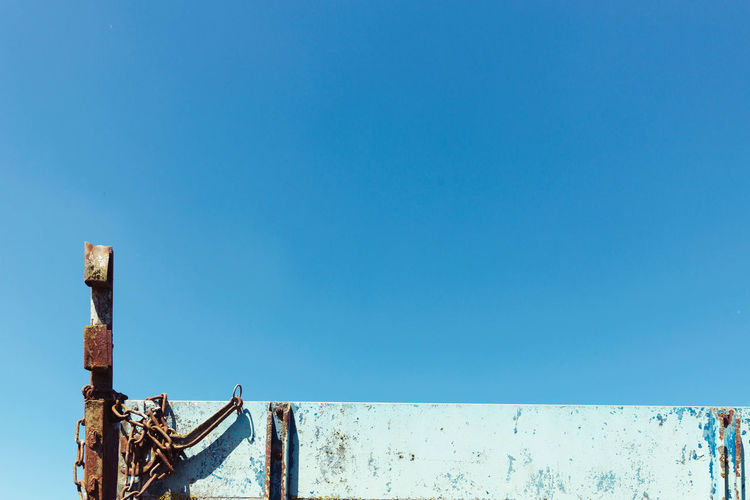 Rusty metal railing against clear blue sky