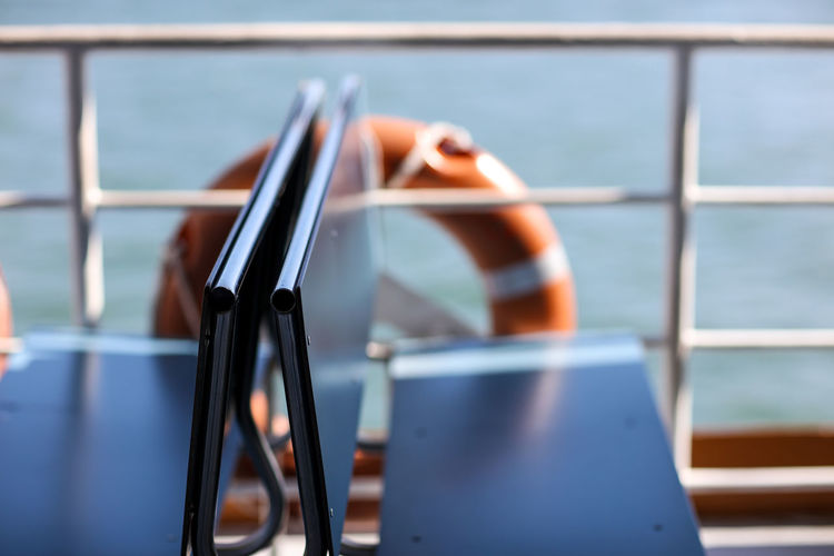 Close-up of benches by railing in boat