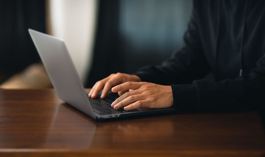 Midsection of businessman using laptop at office
