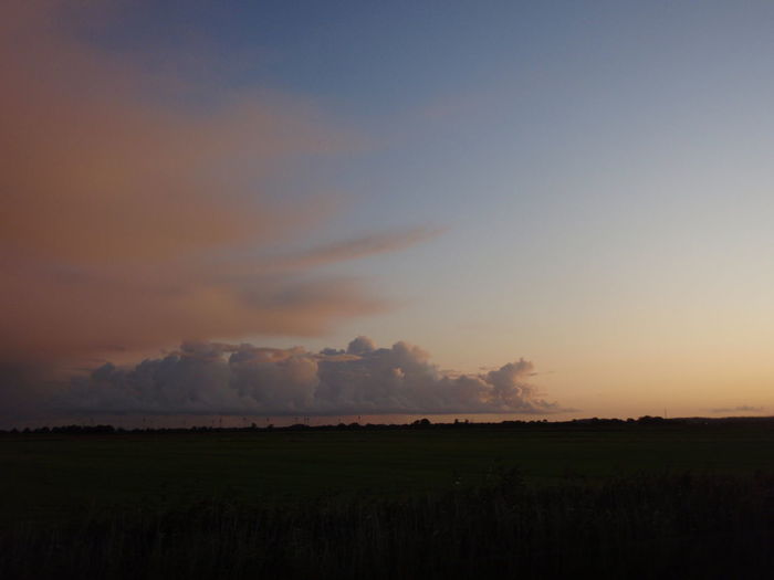 Scenic view of field against sky during sunset