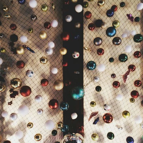 Full frame shot of colorful baubles on netting hanging from ceiling