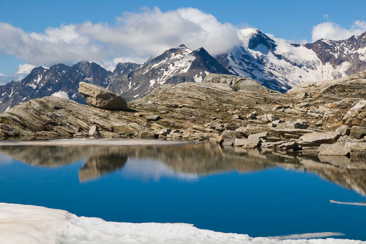 Colorful emerald lake lago smeraldo in the italian alps with monte rosa in the background
