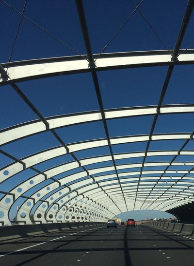 Cars on arch bridge against clear sky