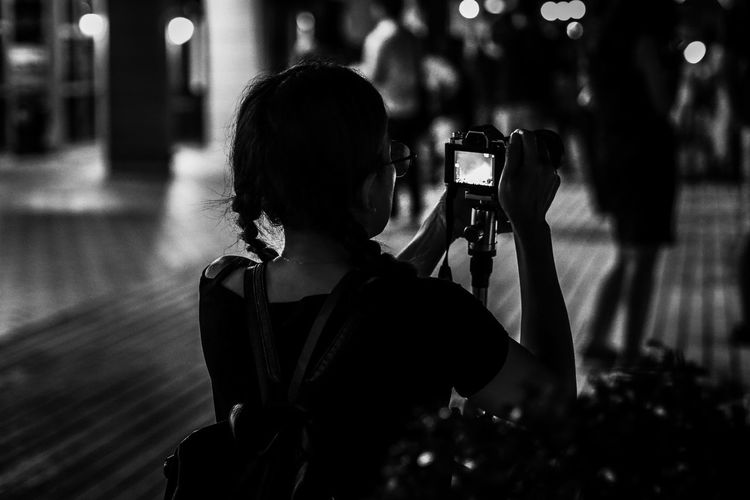 Rear view of woman photographing with camera