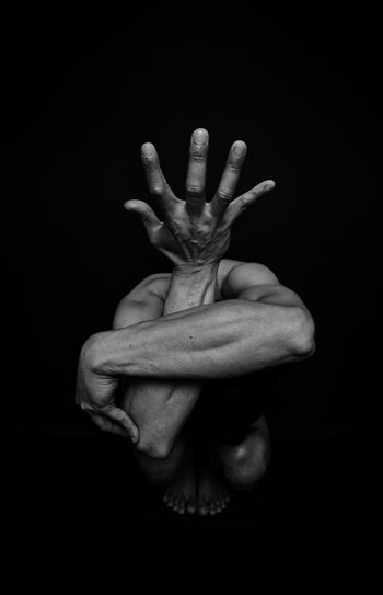 Close-up of human hand against black background