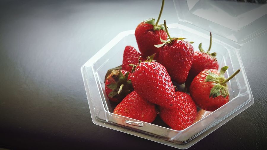 High angle view of strawberries in box on table