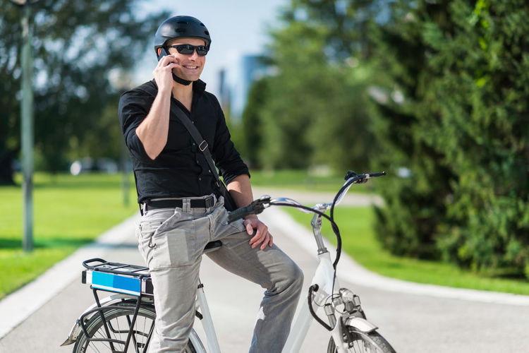 Businessman talking on mobile phone while sitting on bicycle