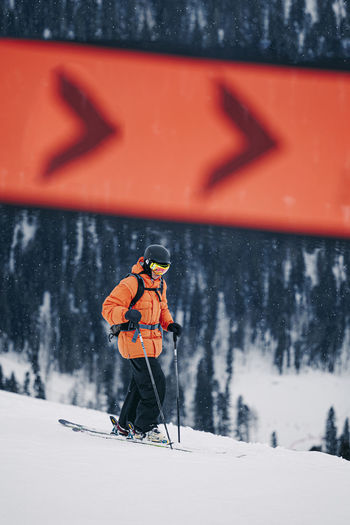 Man with ski pole walking on snow