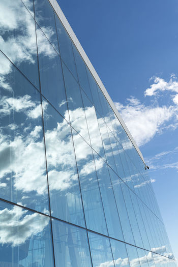 Low angle view of glass building against sky