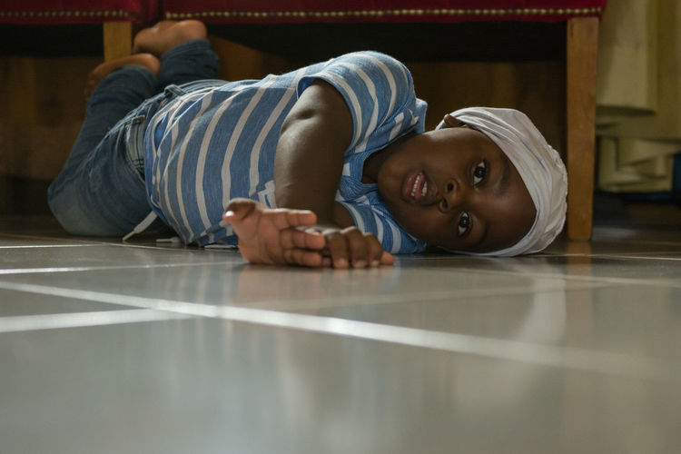 Portrait of boy lying on floor at home