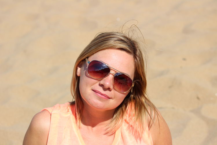 Portrait of mid adult woman wearing sunglasses at beach