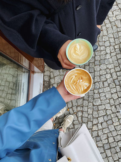 Low section of man holding coffee cup