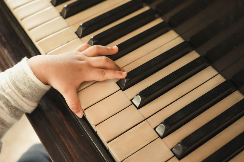 Cropped hand of baby playing piano