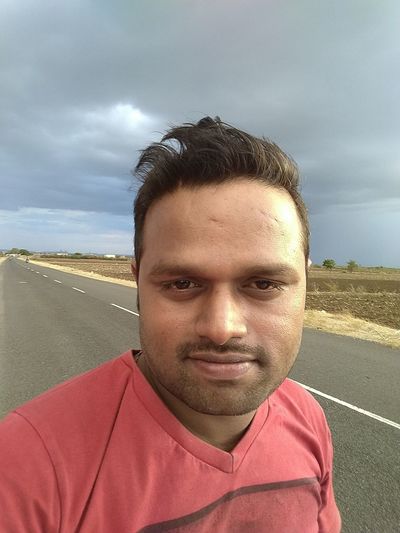 Portrait of man against road against sky