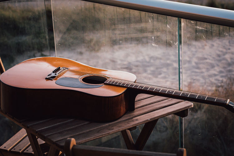 High angle view of guitar on table against railing