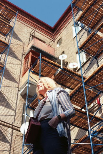 Low angle view of woman standing against building