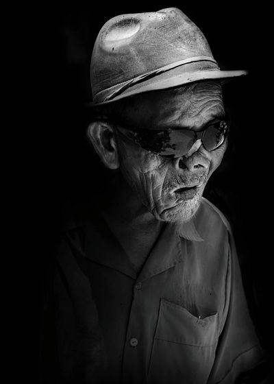 Close-up of blind man against black background