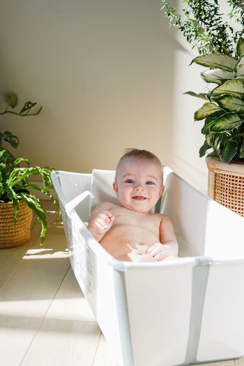 Portrait of cute baby boy in bathtub at home