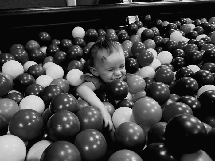 Cheerful toddler playing in ball pool
