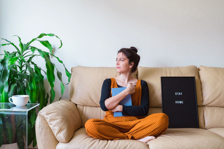 Young woman with book at home