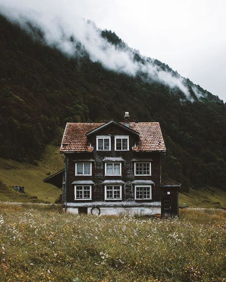 Exterior of house by mountain during foggy weather