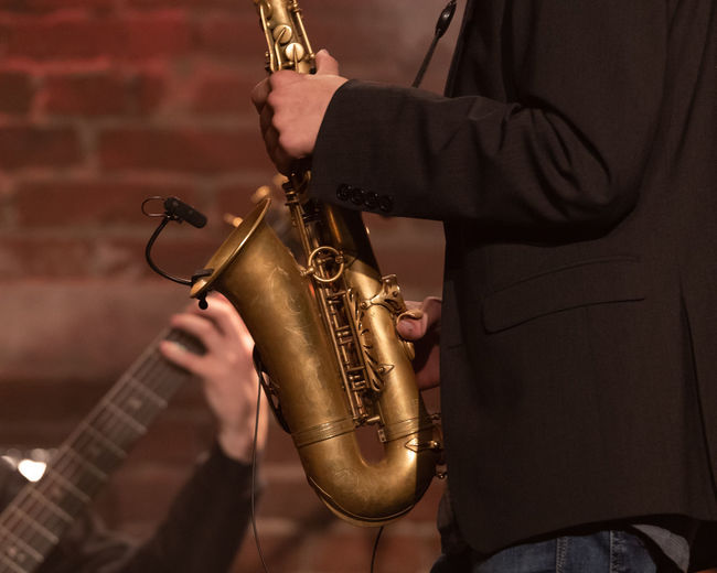 Midsection of man playing saxophone