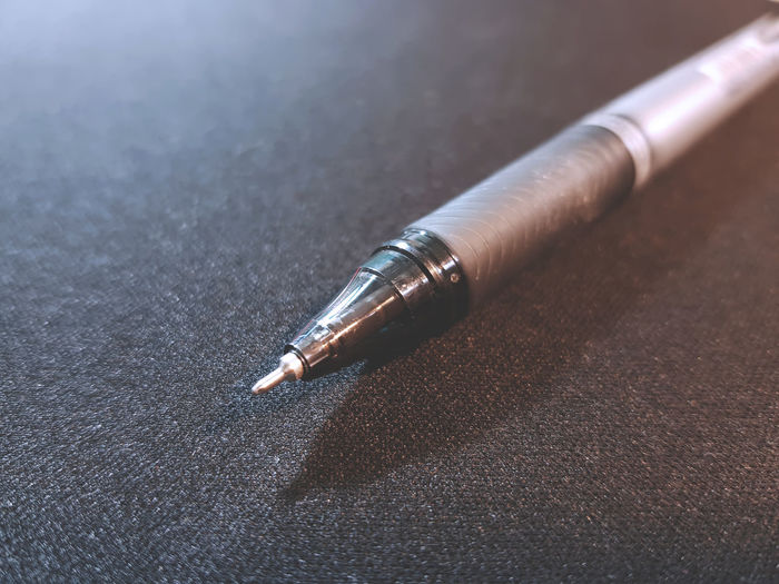 Close-up of pen on black table