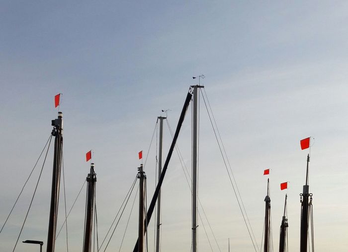 Low angle view of sailing masts against clear sky
