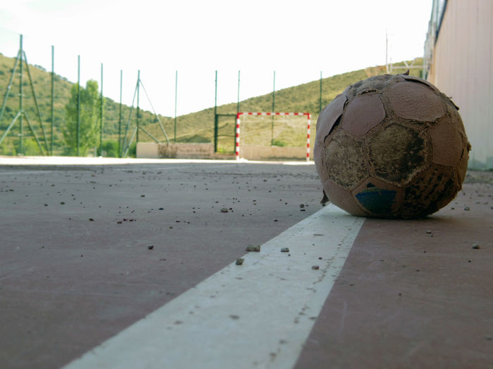 Close-up of soccer ball on field against sky