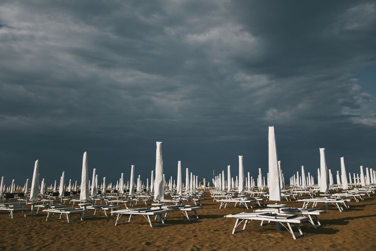 Beach umbrellas against cloudy sky