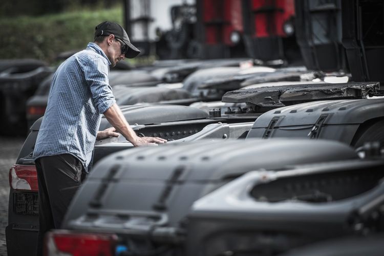 Man standing amidst cars