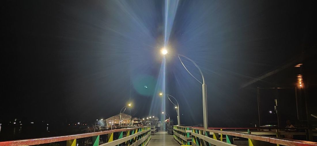 Illuminated bridge against sky at night