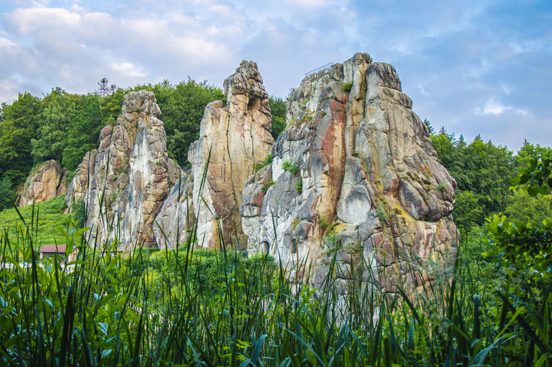 Panoramic view of rock formation amidst trees against sky