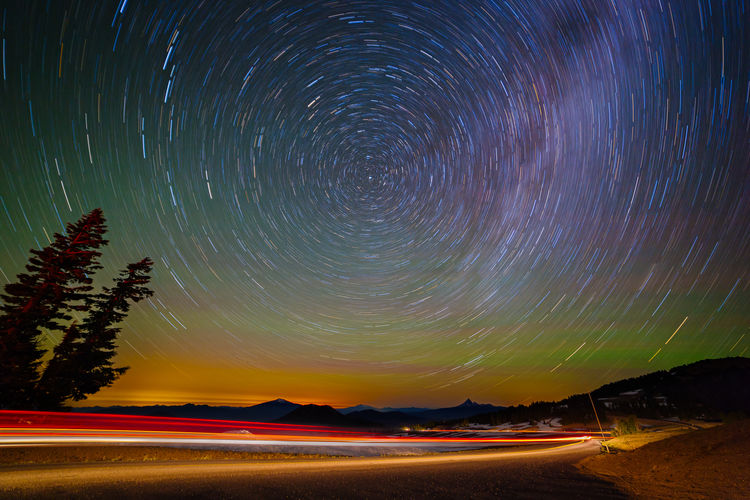 Light trails on road against star trail