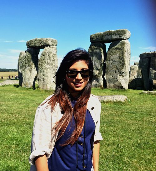 Portrait of young woman wearing sunglasses against stonehenge