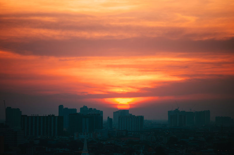 Modern buildings against sky during sunset