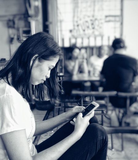 Woman using mobile phone at restaurant
