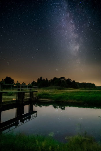 Scenic view of lake against sky at night