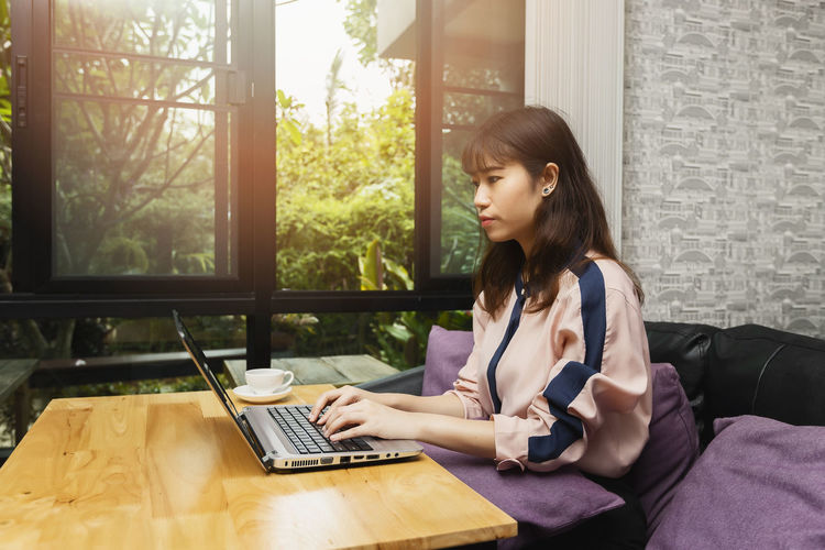 Young businesswoman using laptop while sitting at home
