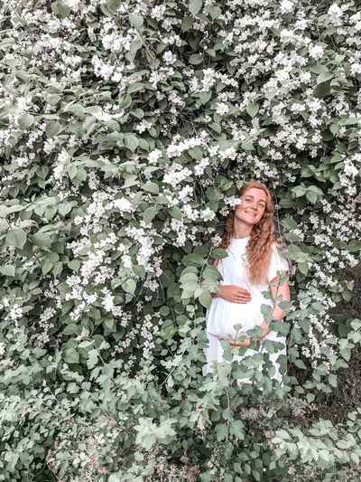 Pregnant woman standing by flowering plants