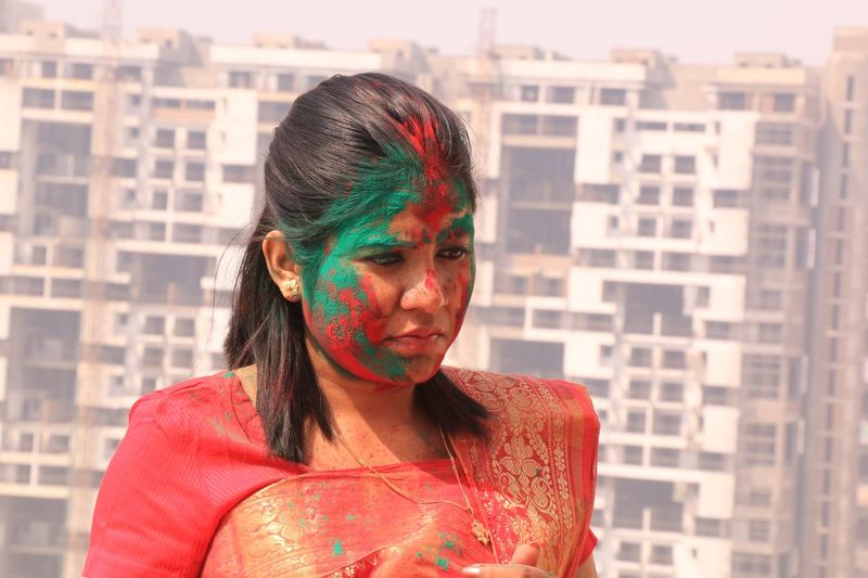 Close-up of young woman with powder paint on face during holi in city